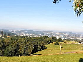 Aufnahme mit Blick von Berg Moriah ins über das Tal mit einer Weide im Vordergrund und einer Baumreihe, die sich von der linken Seite zur Bildmitte zieht. Aufnahme mit Blick von Berg Moriah über das Tal mit einer Weide im Vordergrund und einer Baumreihe, die sich von der linken Seite zur Bildmitte zieht.