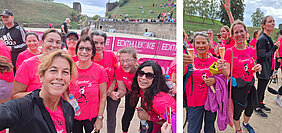 Gruppe von Frauen in pinkfarbenen T-Shirts bei einem Lauf-Event, einige lächeln in die Kamera, im Hintergrund eine Laufstrecke und Zuschauer auf einer Anhöhe
